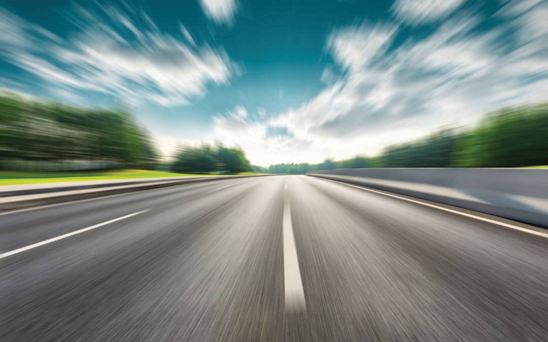 Fast moving road and green forest landscape.