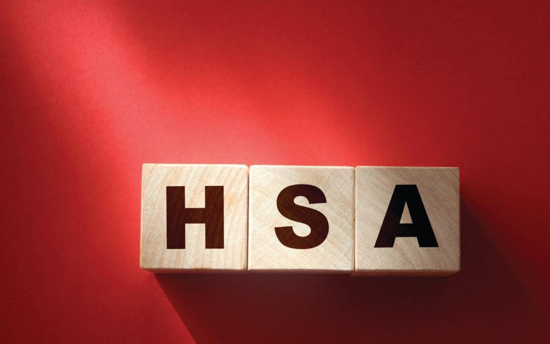 HSA abbreviation on wooden cubes on red. Concept. Health Savings Account.