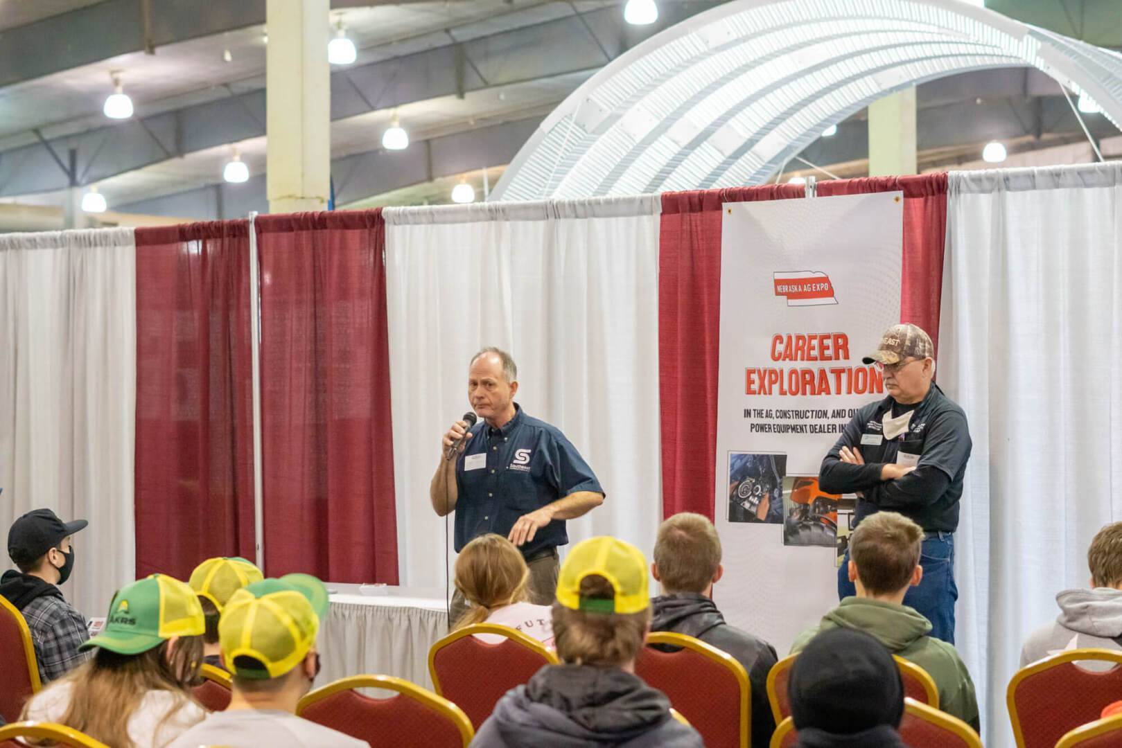 Dealership employees present to students at the career event